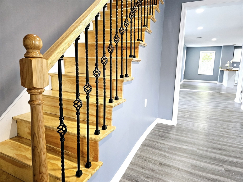 9 Wellington Street Webster, MA 01570 - Photo 24 of 37 a view of hallway with stairs and wooden floor