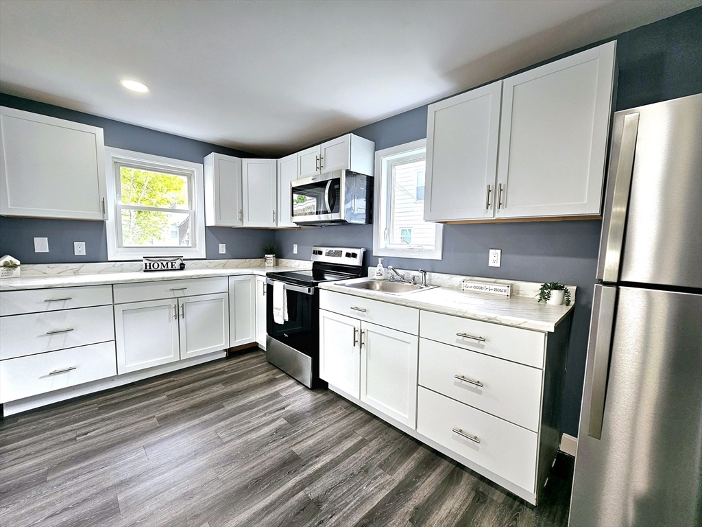 9 Wellington Street Webster, MA 01570 - Photo 5 of 37 a kitchen with white cabinets stainless steel appliances and window