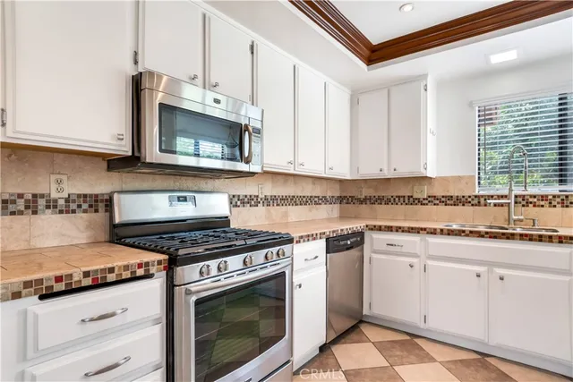 a kitchen with granite countertop white cabinets and white appliances