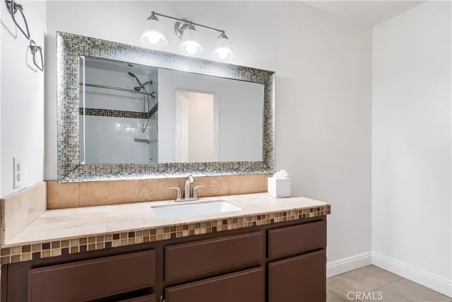 a bathroom with a granite countertop sink and a mirror
