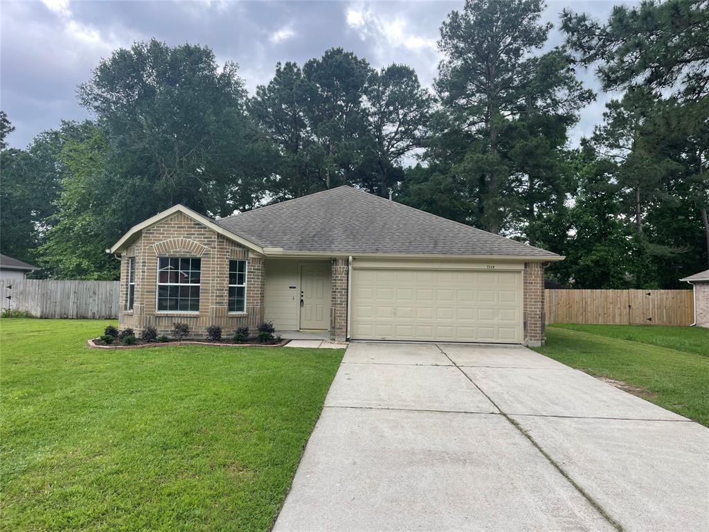 7115 Grant Drive Magnolia, TX 77354 - Photo 1 of 16 a front view of a house with a yard and garage