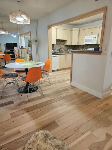 a room with wooden floor table and chairs
