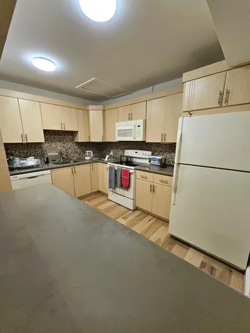 a kitchen with stainless steel appliances granite countertop a refrigerator a stove a sink and a refrigerator