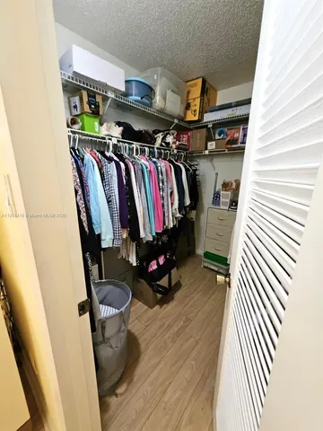 a view of walk in closet with clothes and shoes