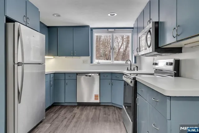 a kitchen with stainless steel appliances granite countertop a refrigerator and a sink