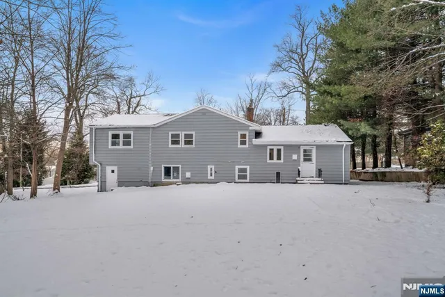 a front view of a house with a yard covered in snow