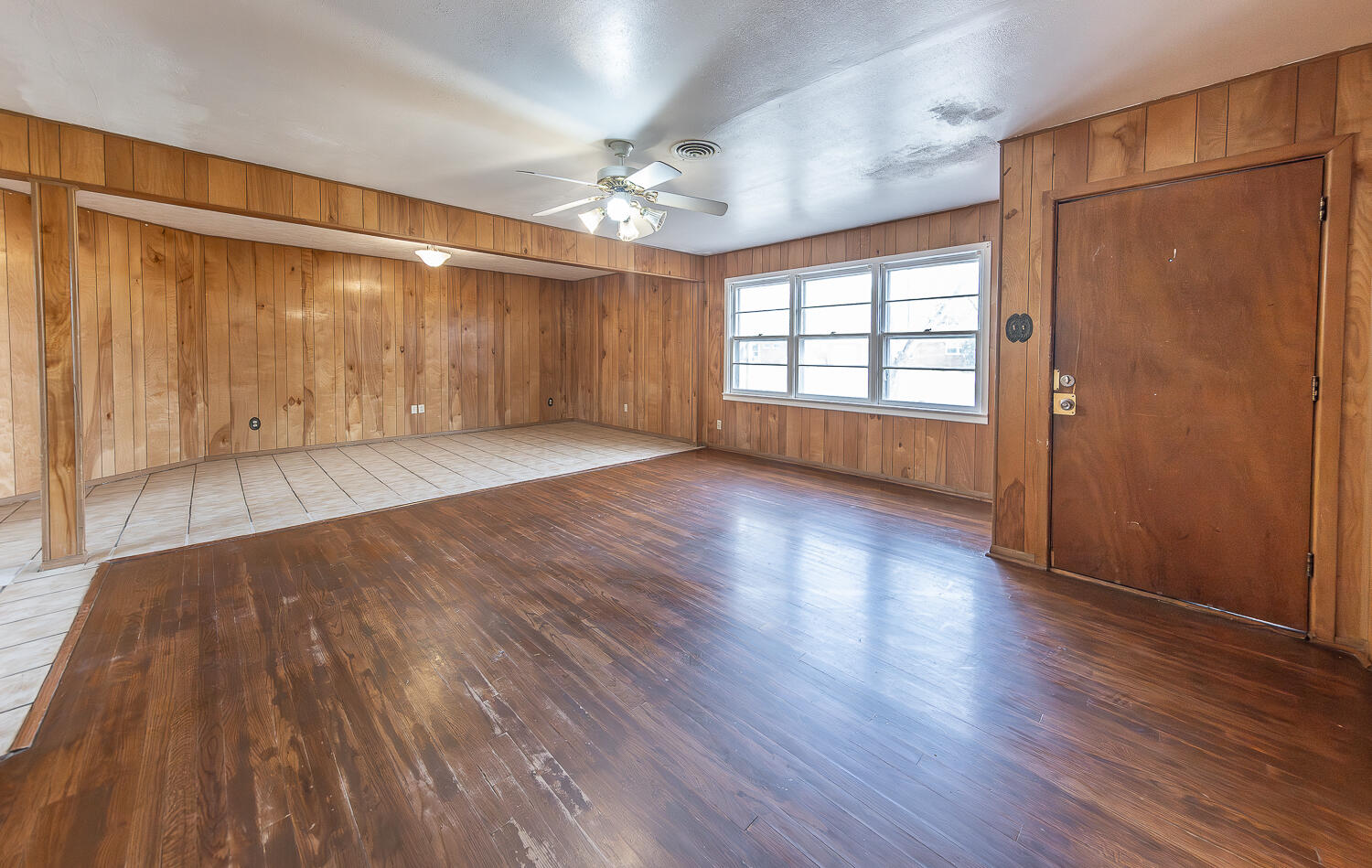 2613 48th Street Lubbock, TX 79413 - Photo 4 of 22 a view of an empty room with wooden floor and a window