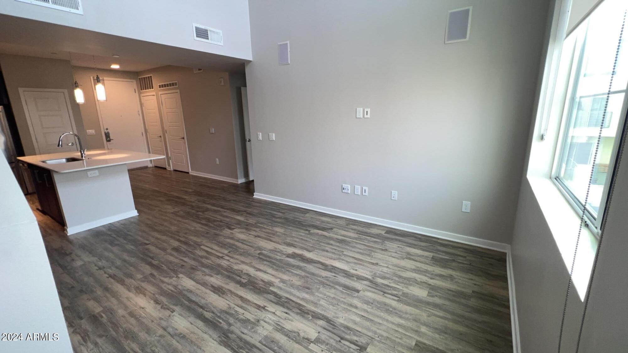 4949 North 7th Street, Unit A3 Phoenix, AZ 85014 - Photo 2 of 22 an empty room with wooden floor and a window