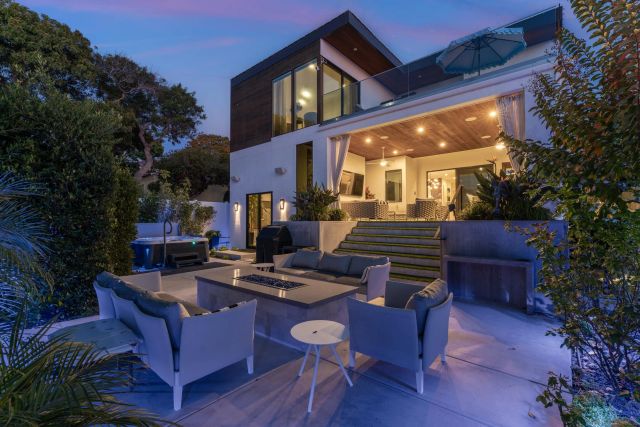 a view of a patio with couches table and chairs and potted plants