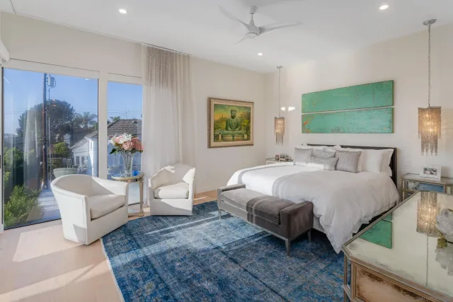 a spacious bedroom with a bed a couch and a flat tv screen