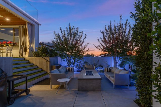 a view of a patio with couches and a potted plant on a table and chairs