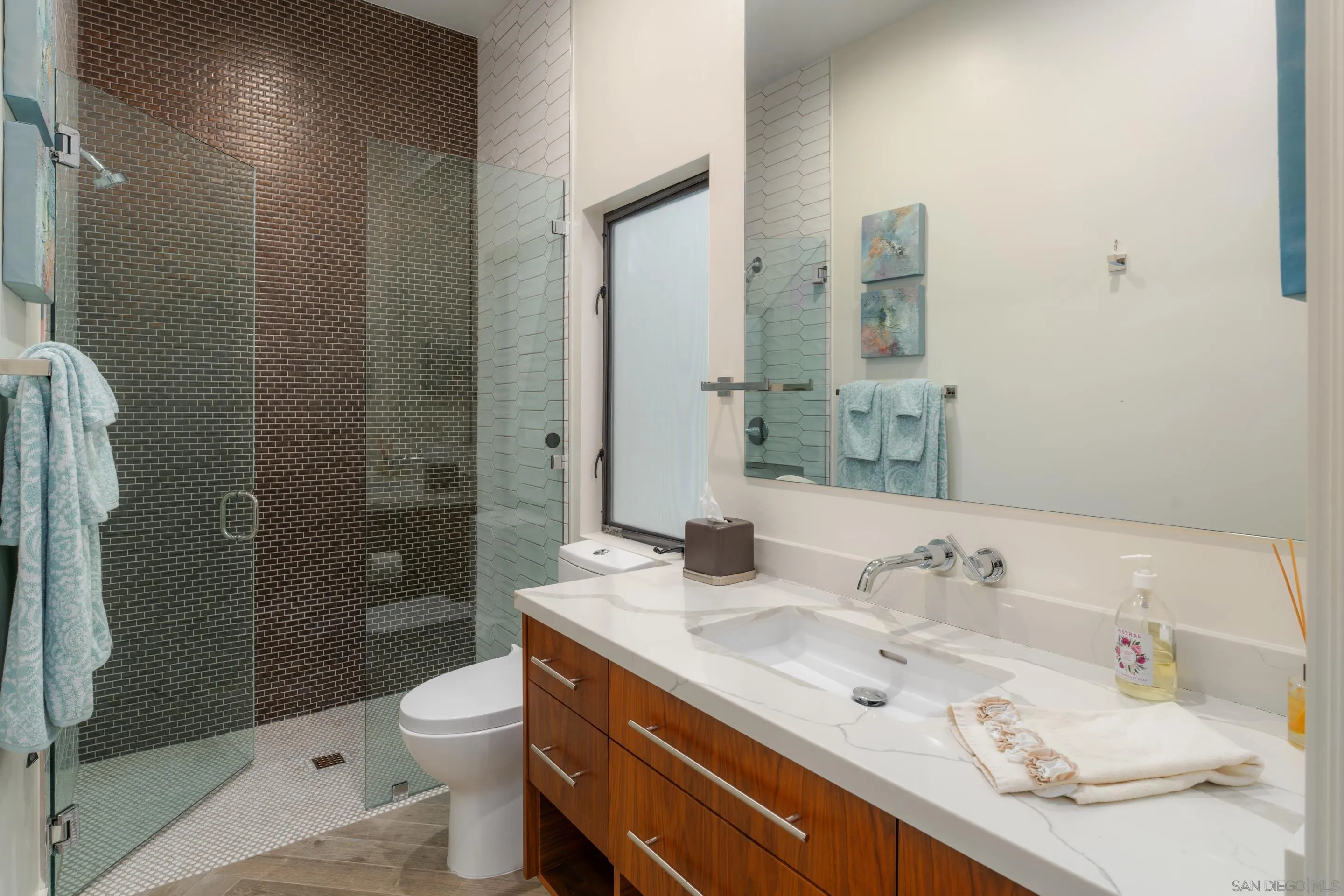 1224 Virginia Way La Jolla, CA 92037 - Photo 37 of 45 a bathroom with a granite countertop sink a toilet and shower