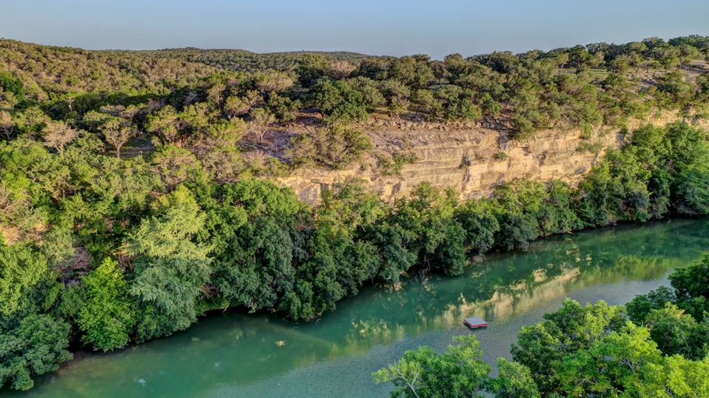 157 Cedar Cliff Loop West Hunt, TX 78024 - Photo 26 of 35 a view of a lake with a building in the background