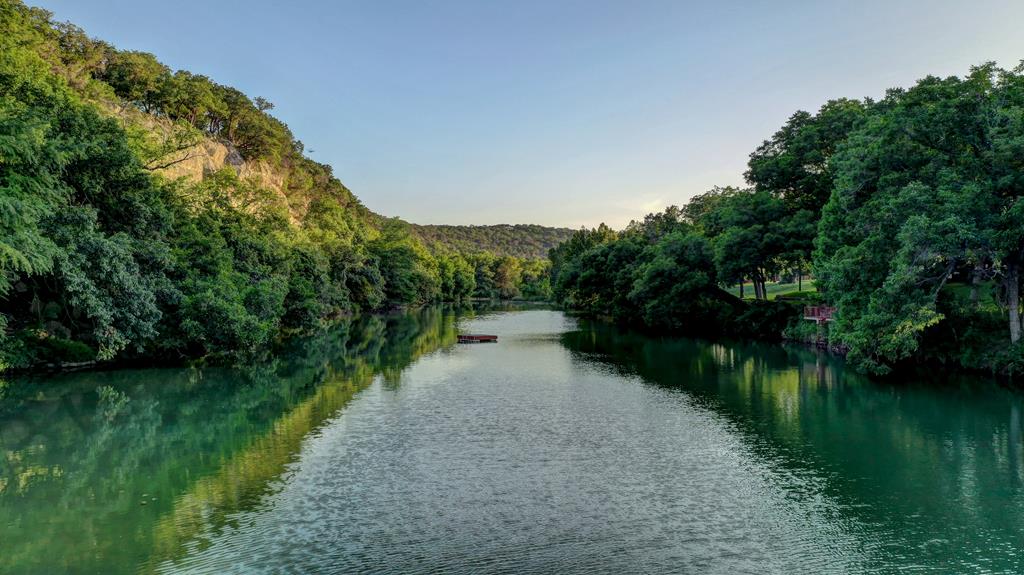 157 Cedar Cliff Loop West Hunt, TX 78024 - Photo 4 of 35 a view of a lake with a yard and large trees