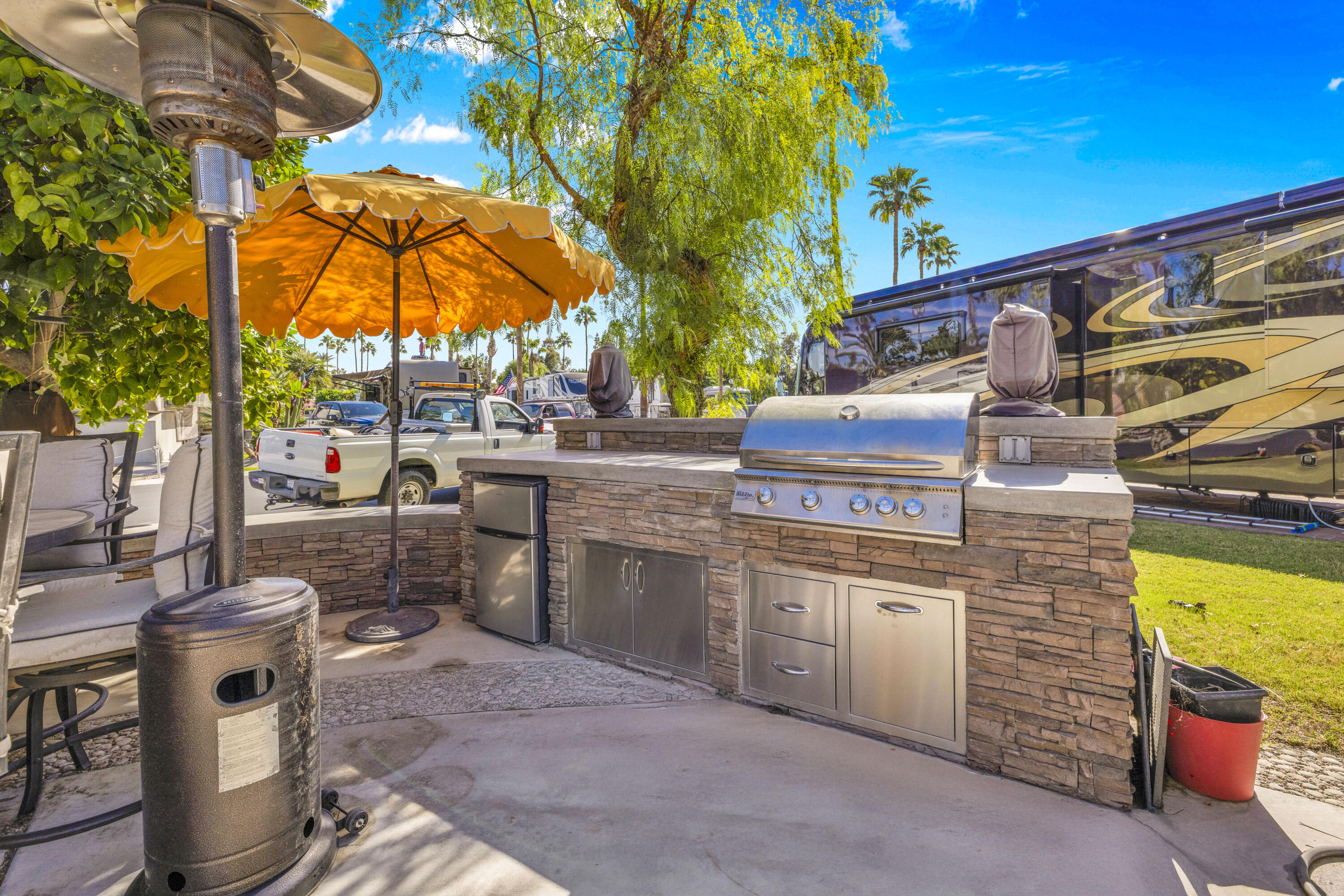69411 Ramon Road, Unit 1011 Cathedral City, CA 92234 - Photo 2 of 46 a view of a backyard with table and chairs under an umbrella