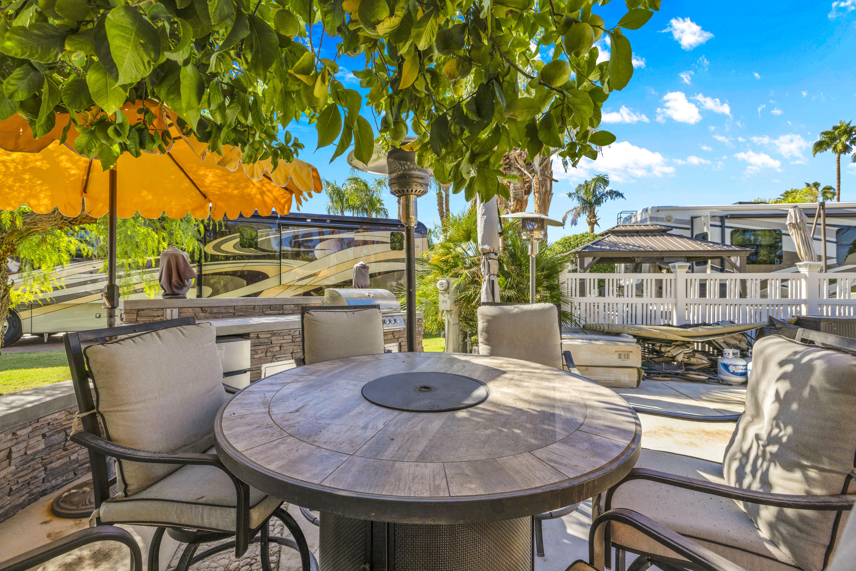69411 Ramon Road, Unit 1011 Cathedral City, CA 92234 - Photo 3 of 46 a view of a patio with table and chairs potted plants and large tree