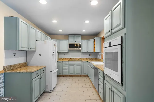 a kitchen with granite countertop a sink and cabinets