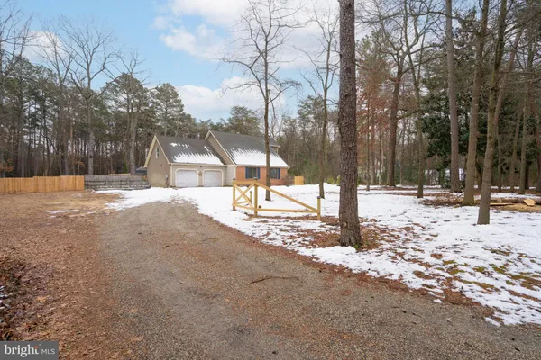 a view of a white house with a yard covered in snow