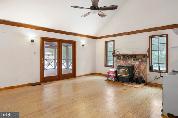 a view of an empty room with a window and wooden floor