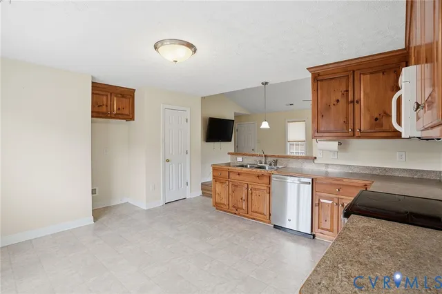 a large kitchen with stainless steel appliances granite countertop a sink and a stove top oven