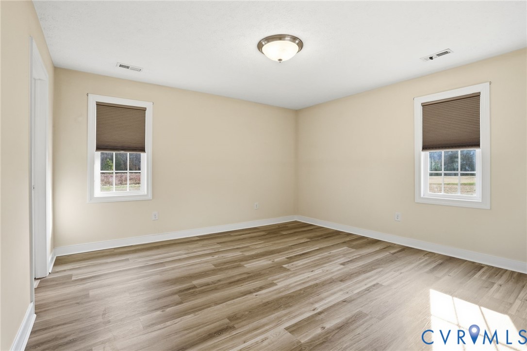 1220 Walkerton Road Walkerton, VA 23177 - Photo 14 of 33 a view of an empty room with wooden floor and a window