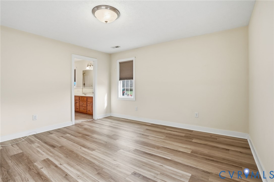 1220 Walkerton Road Walkerton, VA 23177 - Photo 15 of 33 a view of an empty room with wooden floor and a window