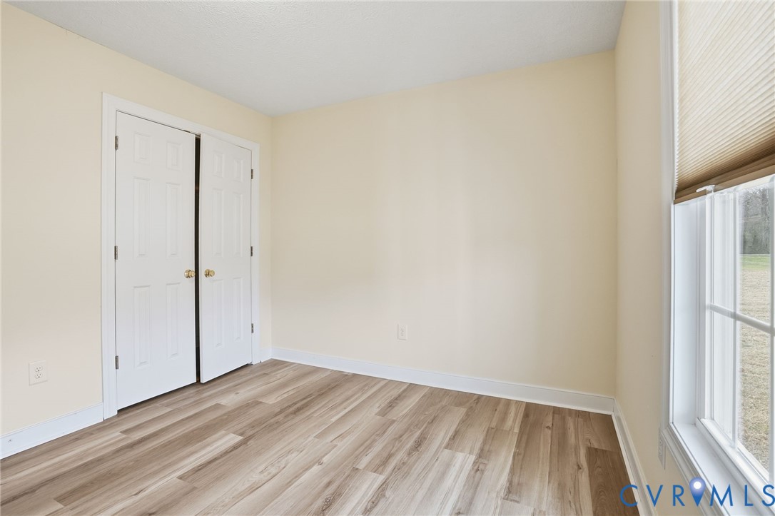 1220 Walkerton Road Walkerton, VA 23177 - Photo 23 of 33 a view of an empty room with wooden floor and a window