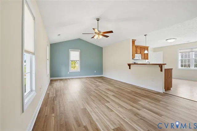 a view of a kitchen with wooden floor a ceiling fan and a window