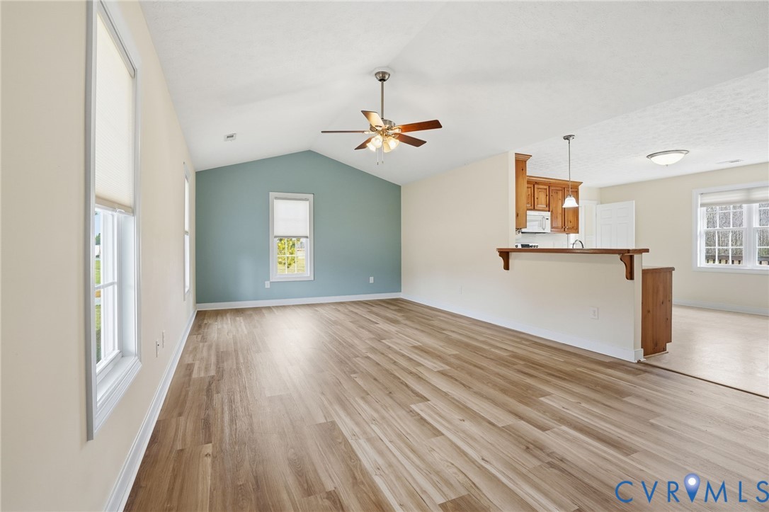 1220 Walkerton Road Walkerton, VA 23177 - Photo 6 of 33 a view of a kitchen with wooden floor a ceiling fan and a window