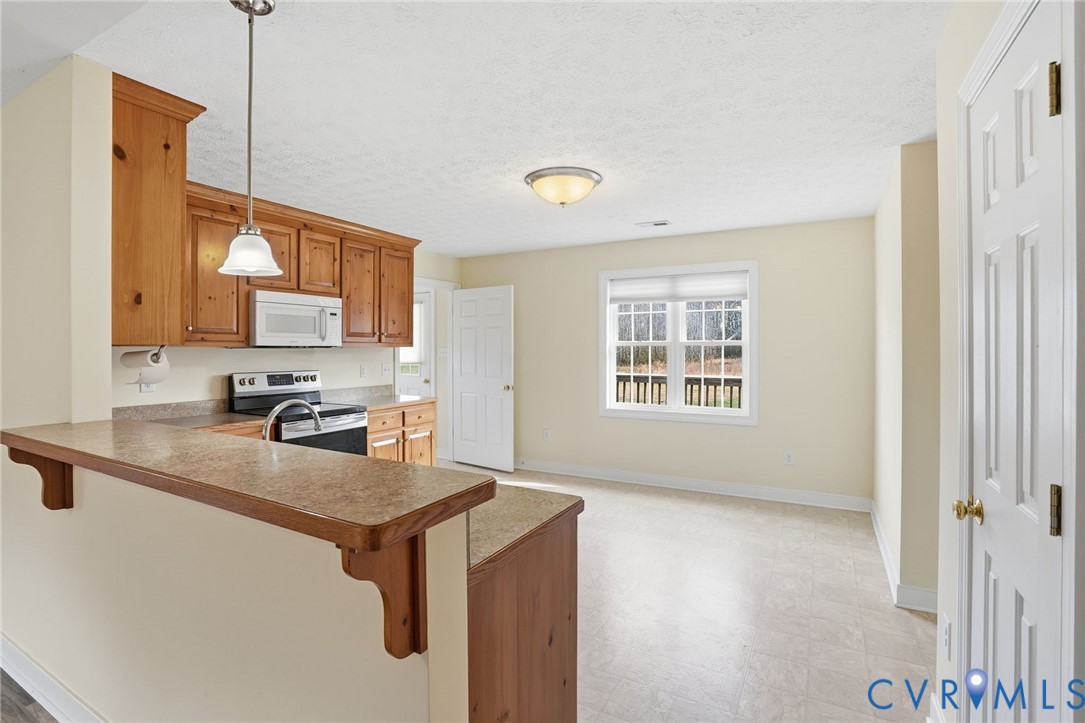 1220 Walkerton Road Walkerton, VA 23177 - Photo 9 of 33 a kitchen with stainless steel appliances granite countertop a sink a stove and a refrigerator