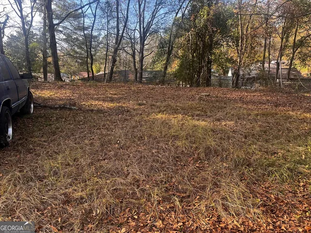 a view of dirt yard with large trees