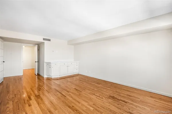 a view of empty room with wooden floor