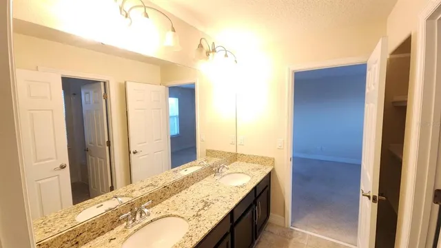 a bathroom with a granite countertop sink and shower