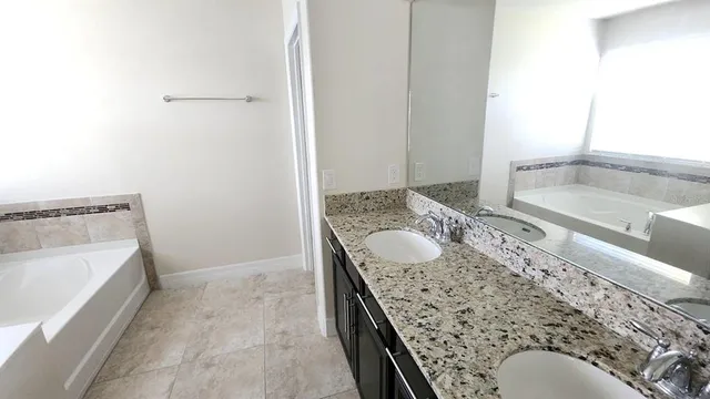 a bathroom with a granite countertop sink and mirror