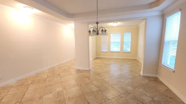 a view of a big room with windows and chandelier fan