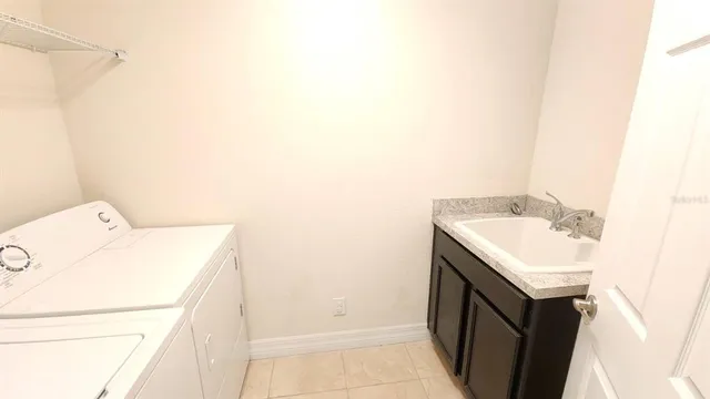 a utility room with a sink washer and dryer