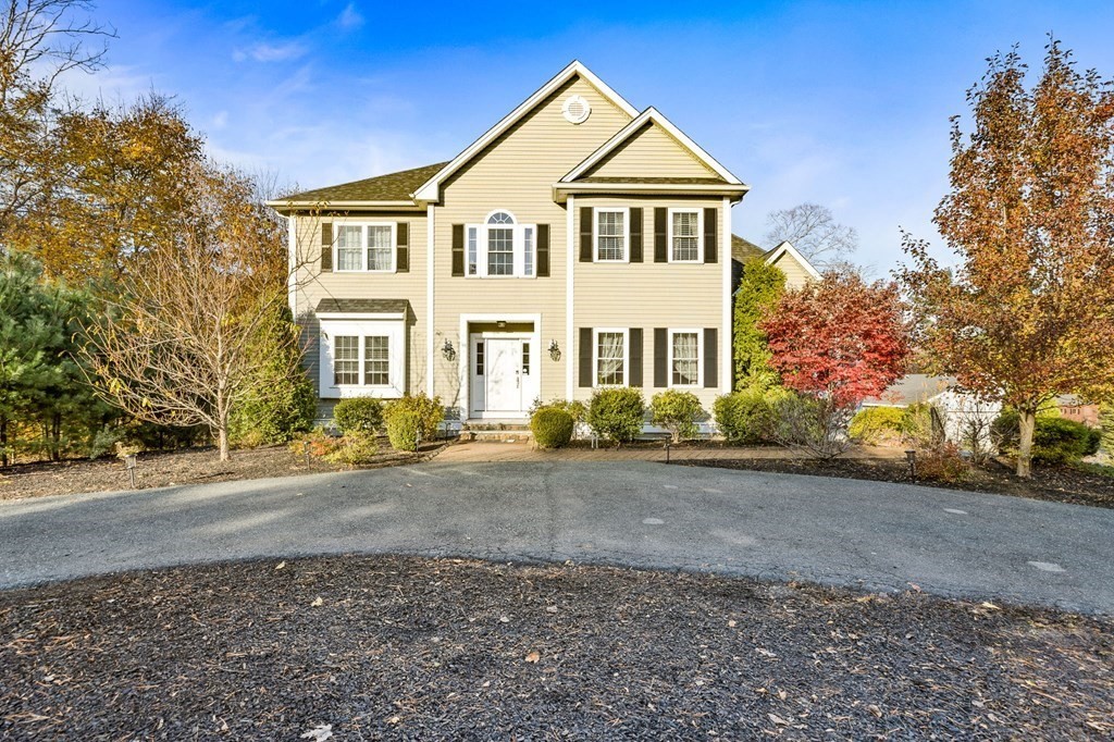 a front view of a house with yard and trees