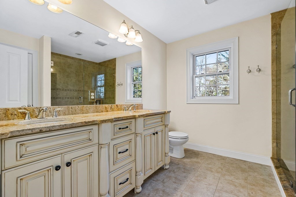 2050 Washington Street Canton, MA 02021 - Photo 22 of 35 a spacious bathroom with a granite countertop toilet sink and a mirror