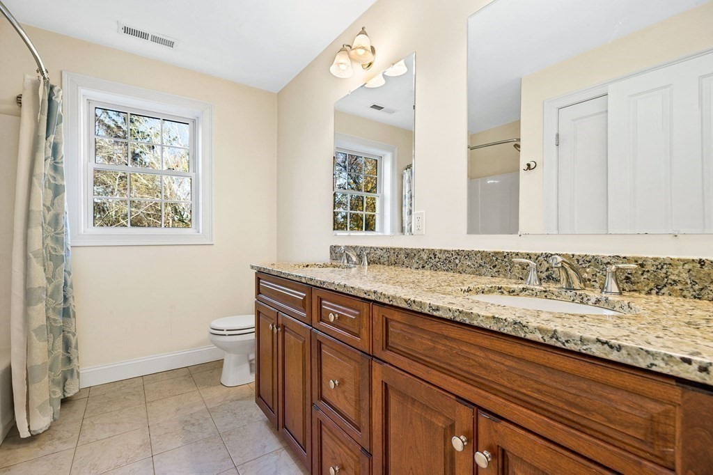 2050 Washington Street Canton, MA 02021 - Photo 26 of 35 a bathroom with a granite countertop sink a toilet and a mirror