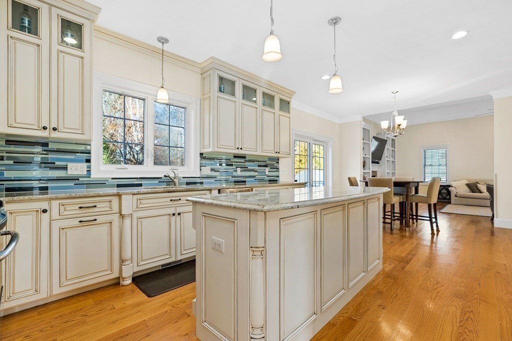 2050 Washington Street Canton, MA 02021 - Photo 4 of 35 a kitchen with stainless steel appliances granite countertop a stove top oven a sink a dining table and chairs with wooden floor