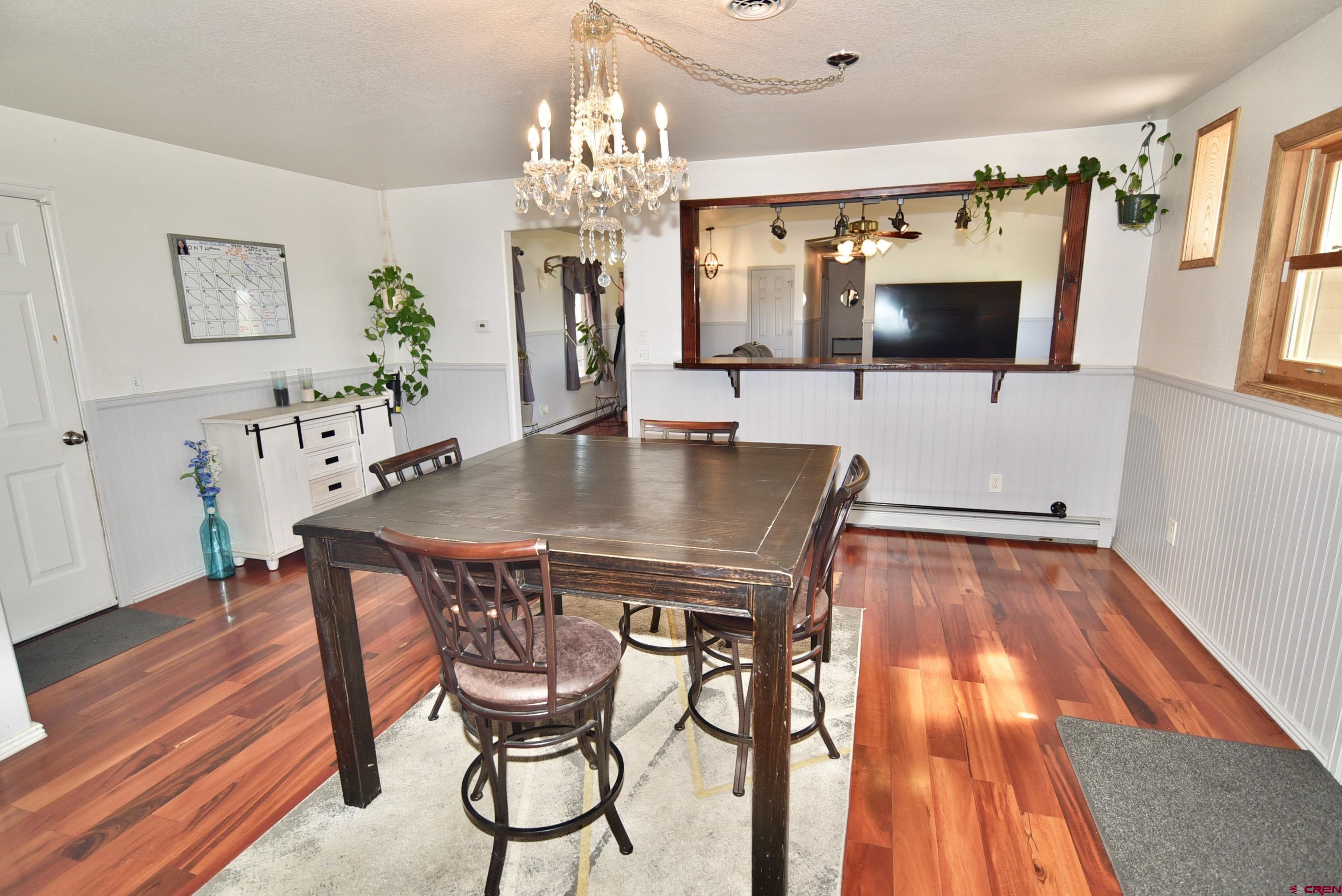 61460 Epitaph Road Montrose, CO 81403 - Photo 13 of 45 a view of a dining room with furniture a chandelier and wooden floor