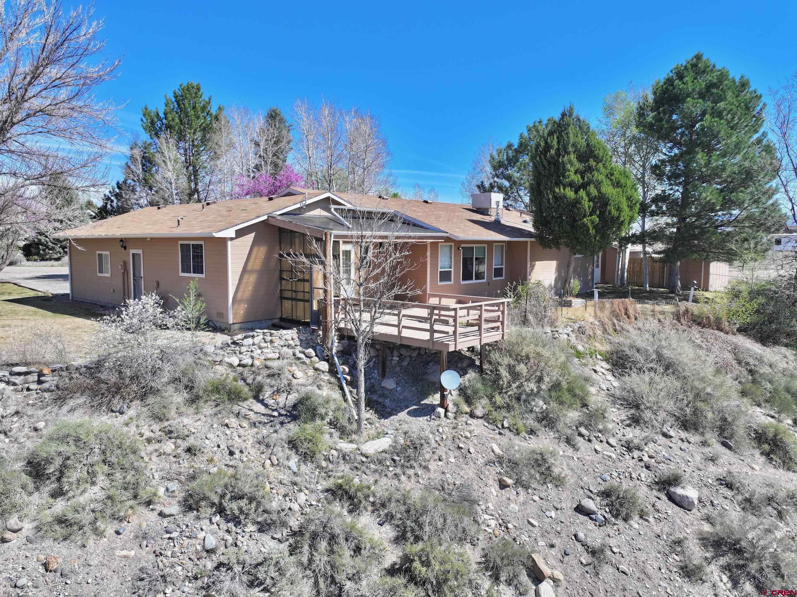 61460 Epitaph Road Montrose, CO 81403 - Photo 4 of 45 a front view of a house with a yard covered by trees