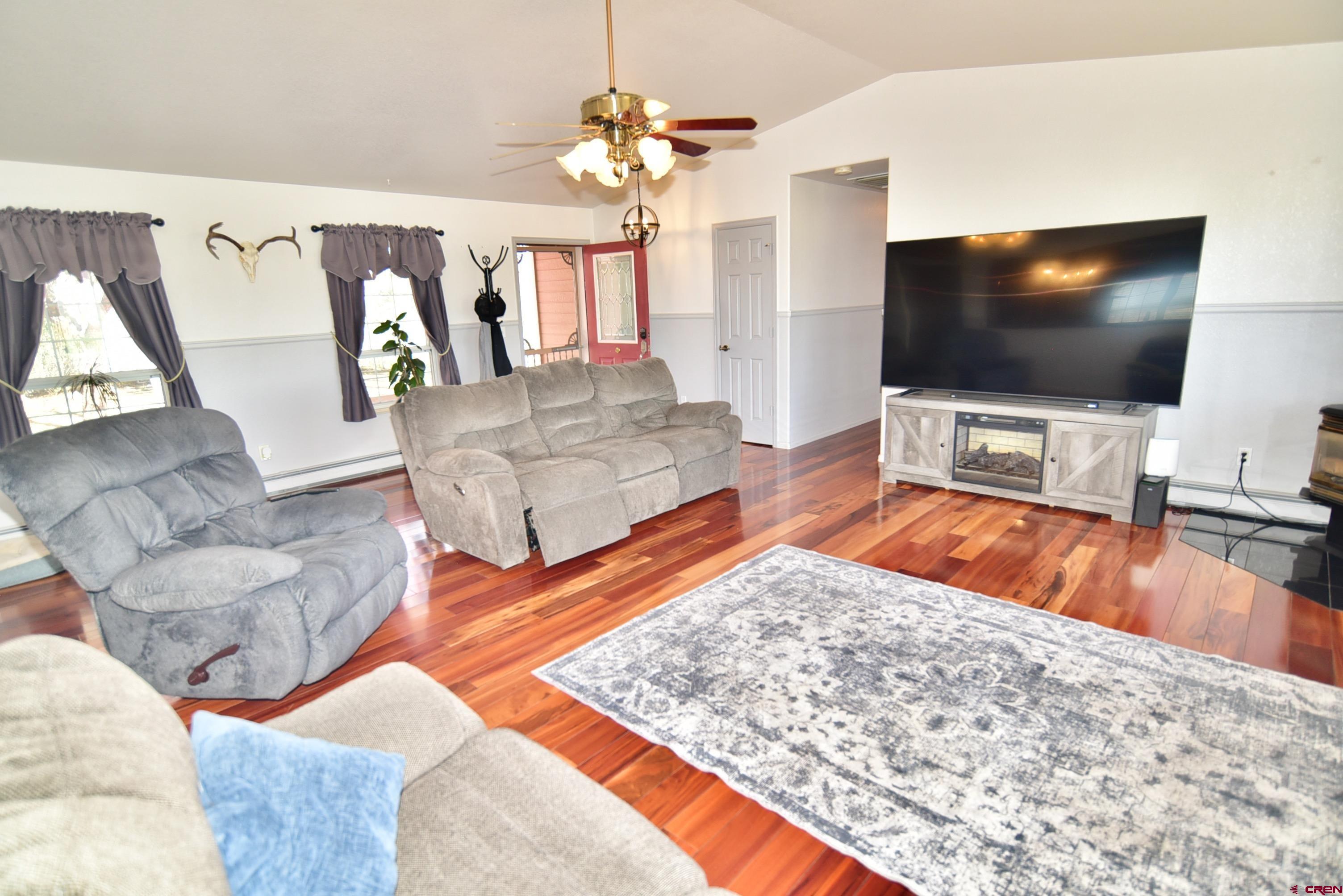 61460 Epitaph Road Montrose, CO 81403 - Photo 8 of 45 a living room with furniture and a flat screen tv