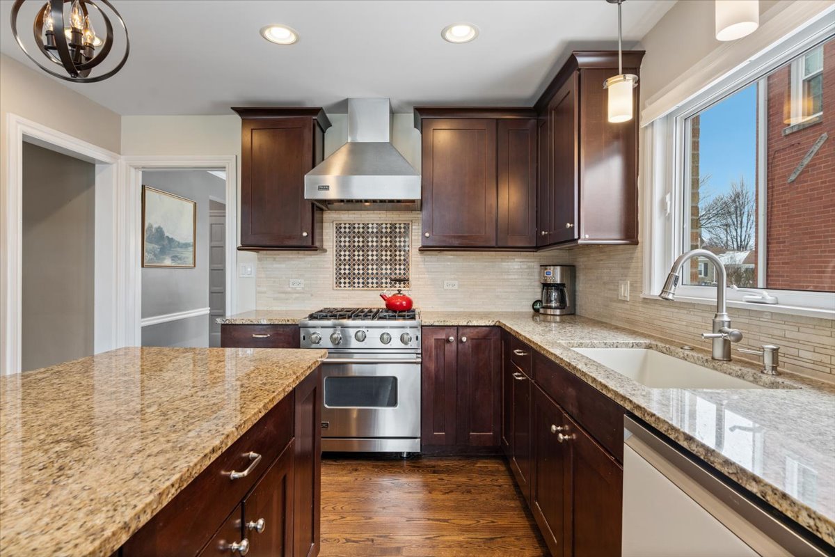 1104 South Lincoln Avenue Park Ridge, IL 60068 - Photo 11 of 37 a kitchen with kitchen island granite countertop a sink a stove and a wooden cabinets