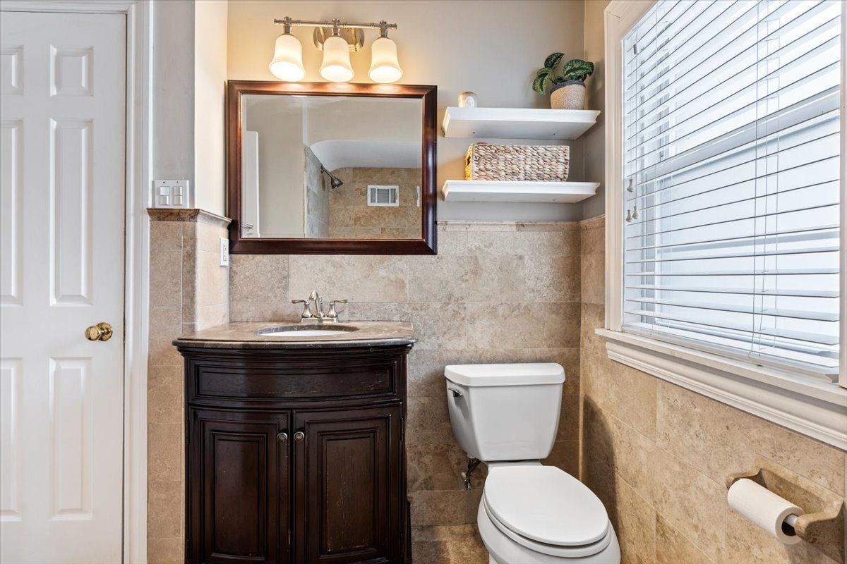 1104 South Lincoln Avenue Park Ridge, IL 60068 - Photo 15 of 37 a bathroom with a granite countertop toilet sink and mirror