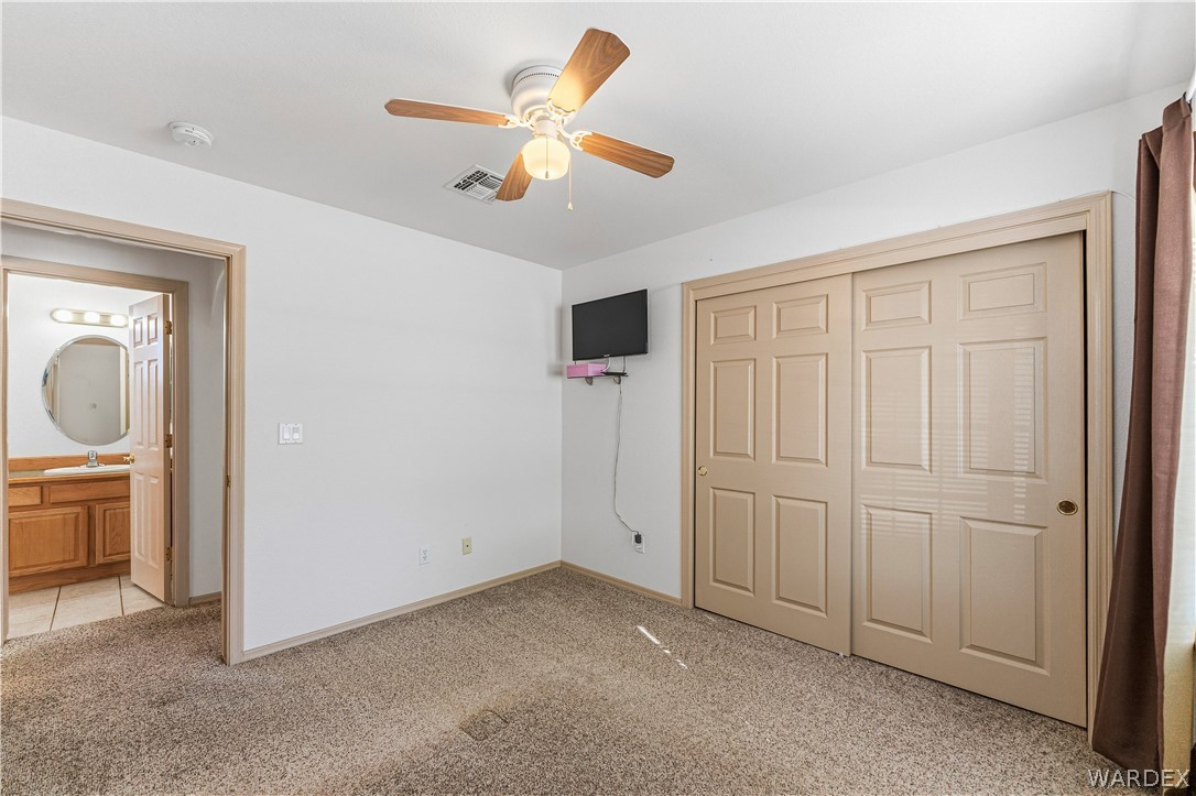3973 Prairie View Drive Kingman, AZ 86409 - Photo 22 of 34 This room features a ceiling fan, carpeted flooring, and a large closet with sliding doors
