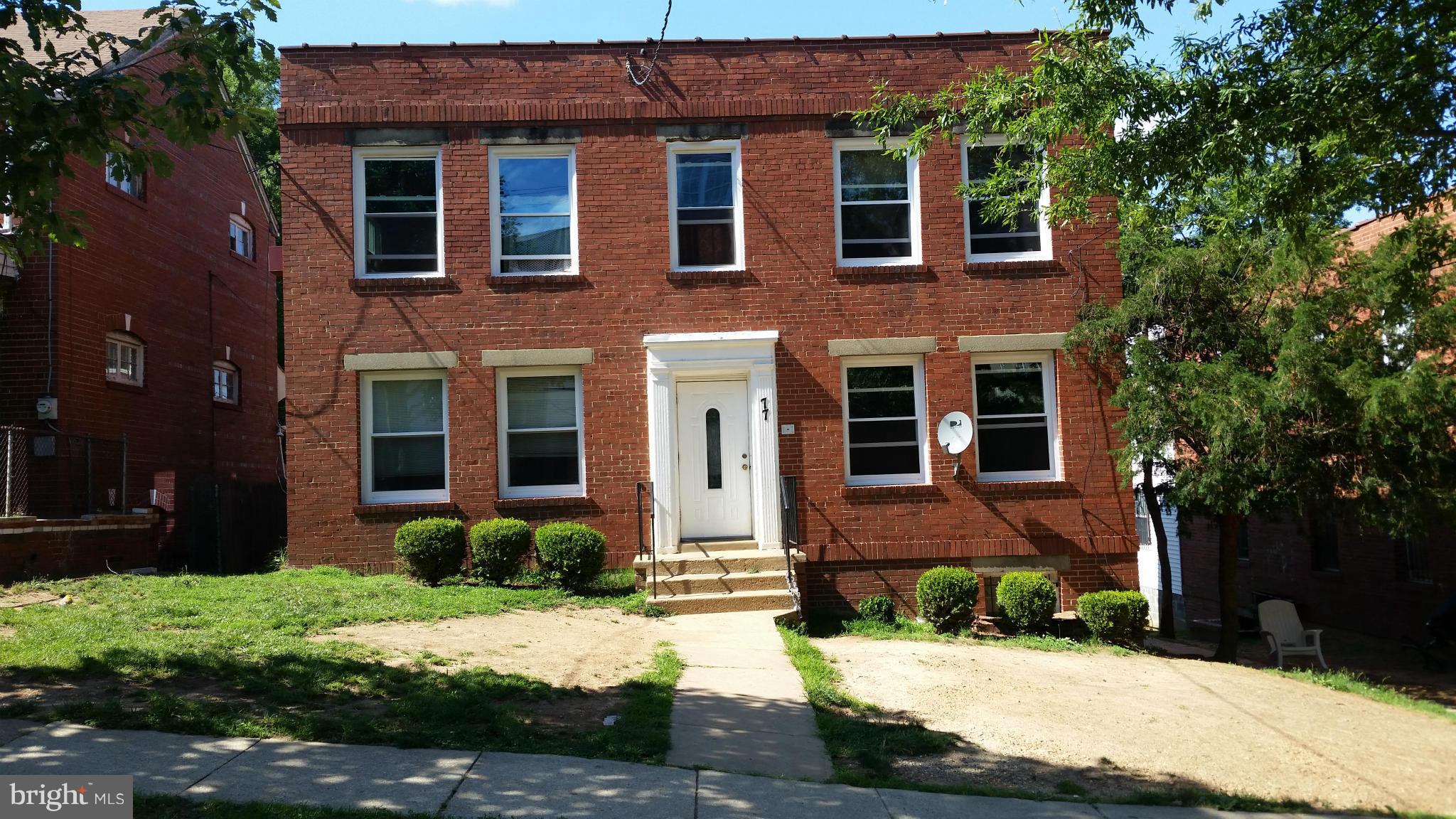 77 Forrester Street Southwest Washington, DC 20032 - Photo 12 of 22 a front view of a house with a yard and trees