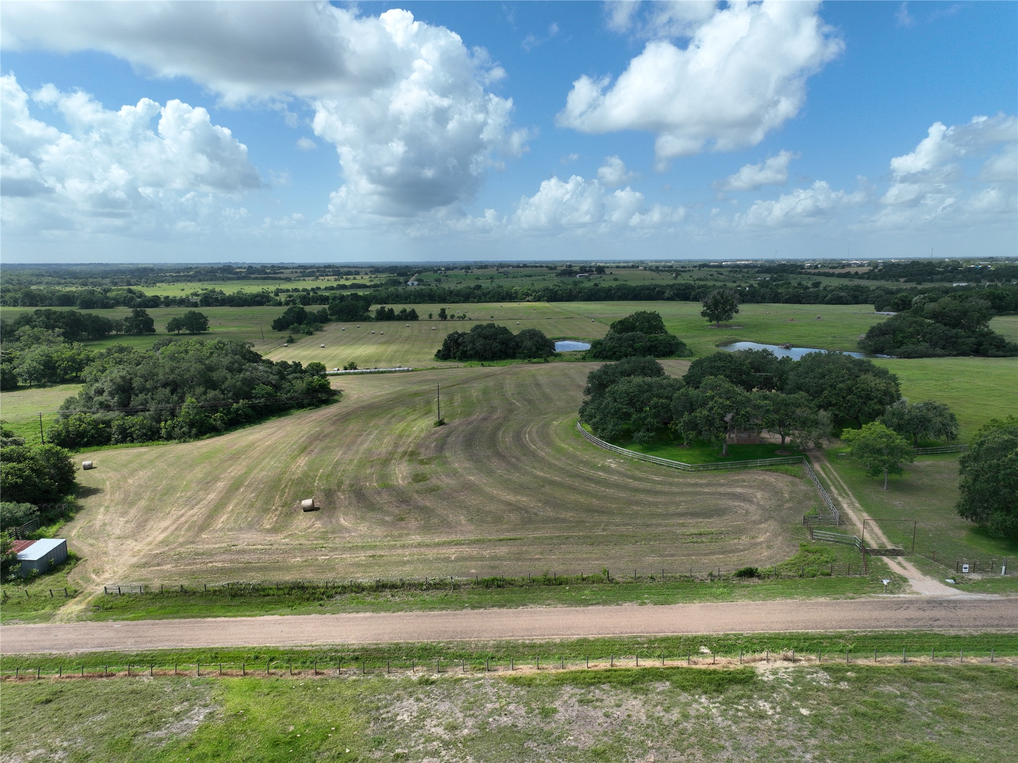 Cultivated fields, verdant trees, and tranquil ponds create a serene rural landscape.