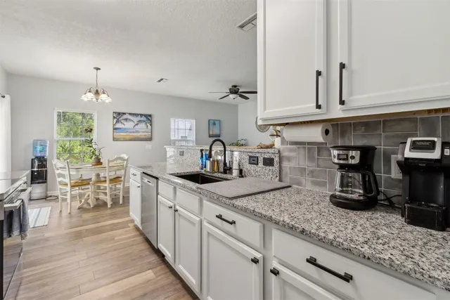 a kitchen with stainless steel appliances granite countertop a stove a sink a microwave and wooden cabinets