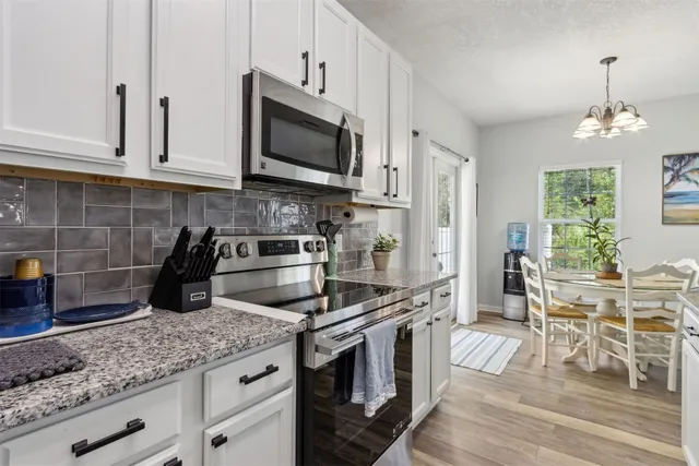 a kitchen with granite countertop a sink stove and refrigerator